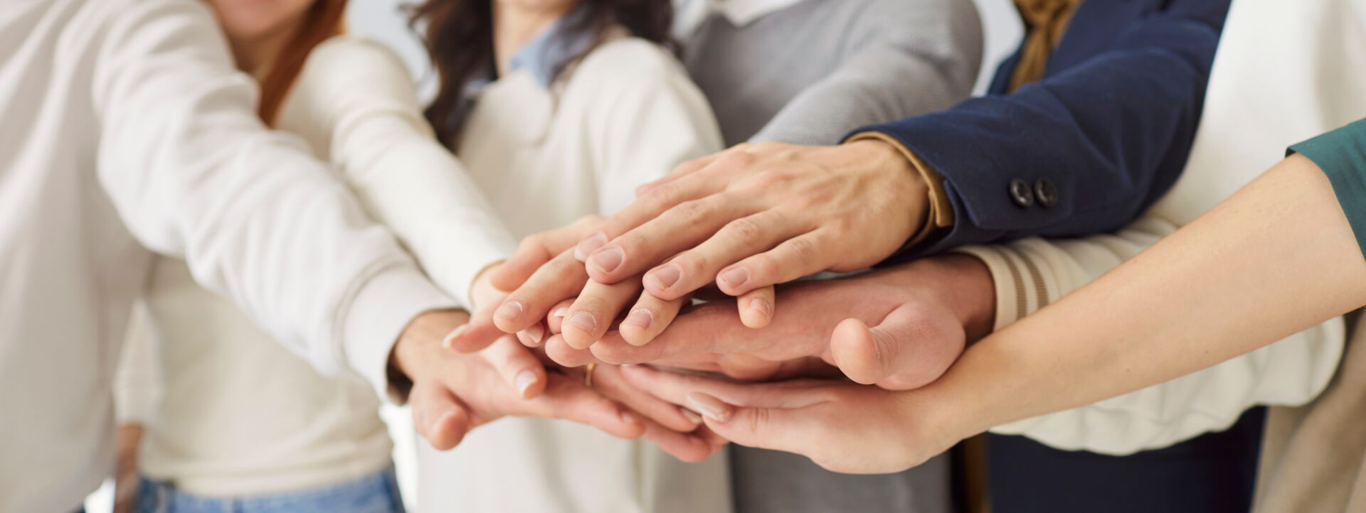 Das Team der Praxis in motio aus Schneeberg legt als Symbol für Zusammenhalt die Hände übereinander.