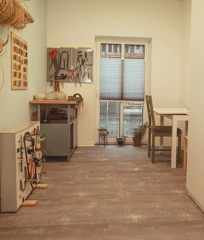 Ergotherapie-Werkstatt bei in motio Schneeberg mit Werkbank, Werkzeugen und einem Trainingstisch.